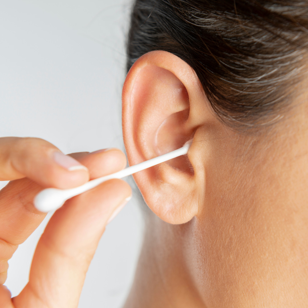 A person cleaning their ear with a cotton swab.